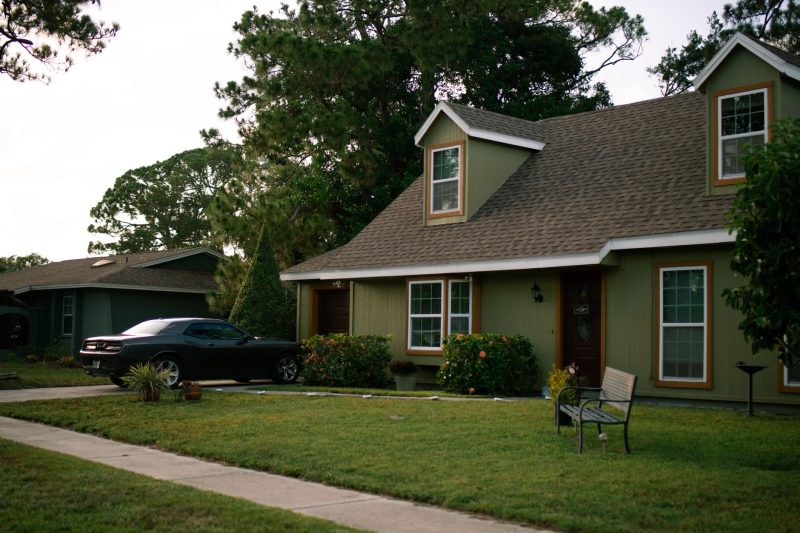 Beautiful suburban home with a manicured lawn and a parked car, showcasing residential comfort.